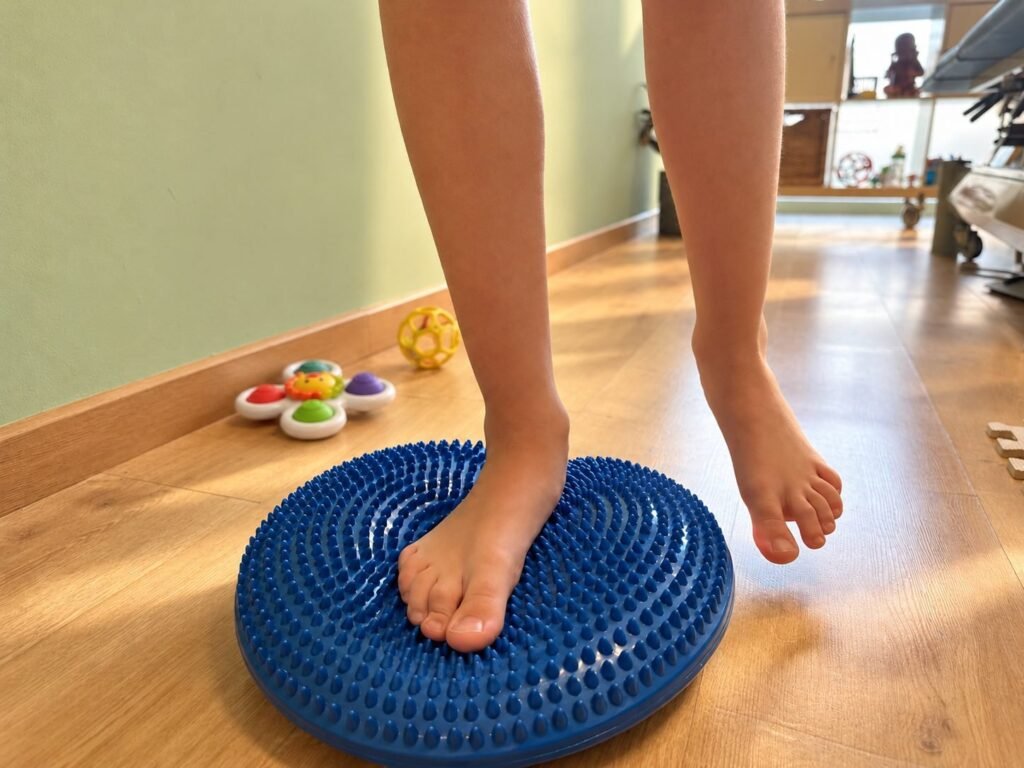 Niña trabajando el equilibrio sobre un disco en la consulta