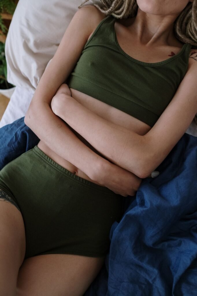 Mujer tumbada abrazándose la barriga