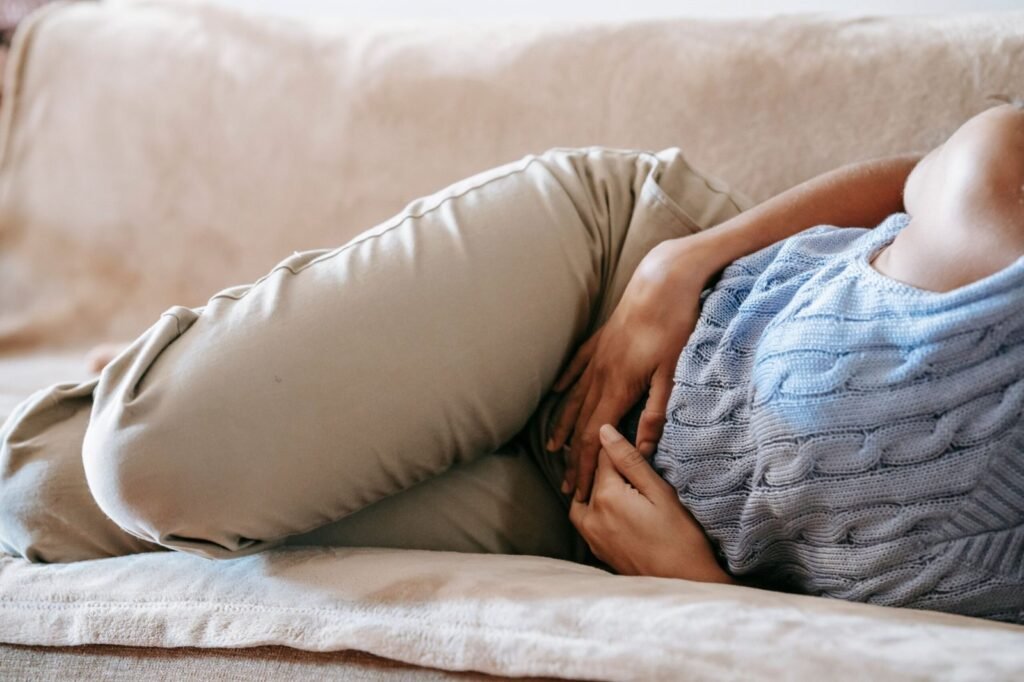 Mujer tumbada en el sofá con molestias pélvicas